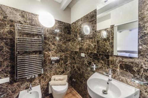 a bathroom with a sink toilet and a mirror at Luxury Apartment Venice in Venice