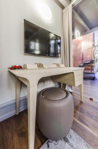 a desk with a television on a wall with a stool at Luxury Apartment Venice in Venice