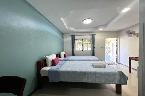 a bedroom with two beds and a window at Saithong Resort in Udon Thani