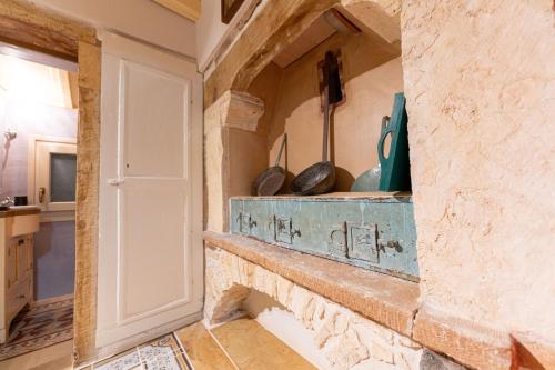 a kitchen with a stone wall with a shelf at Irene's Mansion in Vrontados