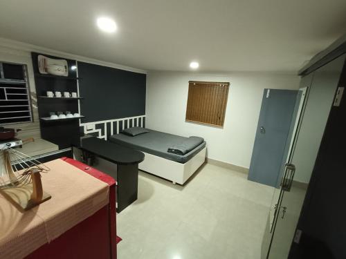 a small room with a bed and a bathroom at Areca Homestay in Guwahati