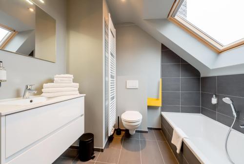 W łazience znajduje się umywalka, toaleta i wanna. w obiekcie Smartflats Design - Schuman w Brukseli