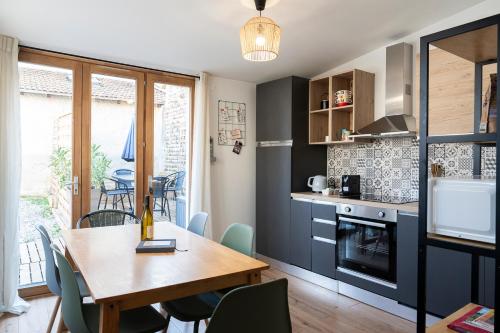 une cuisine et une salle à manger avec une table et des chaises dans l'établissement La Maison de Charlioté, entier, 3chb, 4 à 6 pers, à Miribel