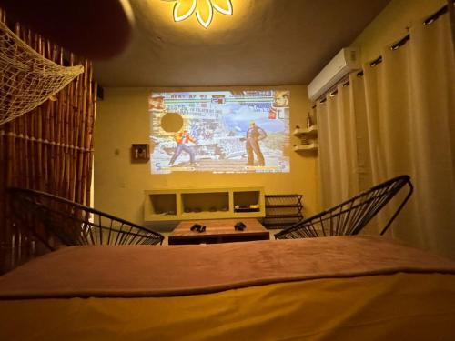 a room with a projection screen and a table and chairs at Casa de vacaciones completa in Acapulco