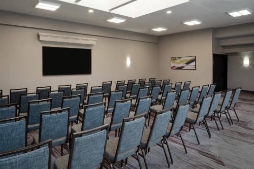 a conference room with chairs and a screen at Courtyard by Marriott Dulles Airport Herndon/Reston in Herndon