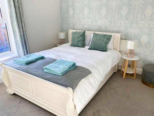 a white bed with two pillows on it in a bedroom at Tudor Delightful House Central Gloucester By StayStaycations in Gloucester