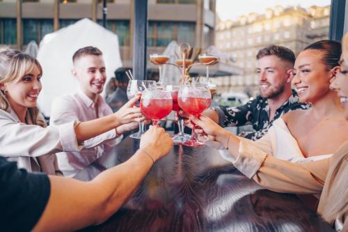 a group of people holding up wine glasses at County Hotel & County Aparthotel Newcastle in Newcastle upon Tyne