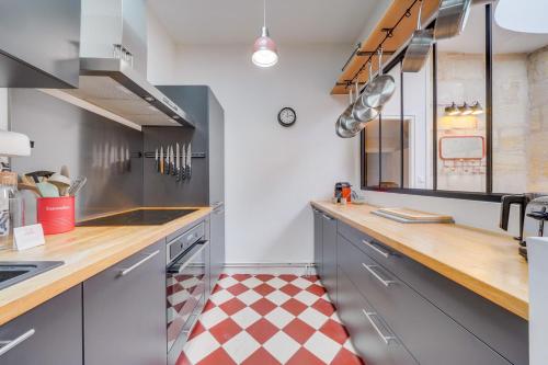- une cuisine avec un sol en damier rouge et blanc dans l'établissement L'Odéia - Chamant appt en plein coeur de Bordeaux, à Bordeaux