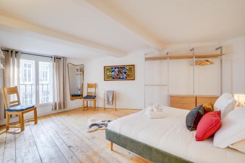 - une chambre avec un grand lit blanc et des chaises dans l'établissement L'Odéia - Chamant appt en plein coeur de Bordeaux, à Bordeaux