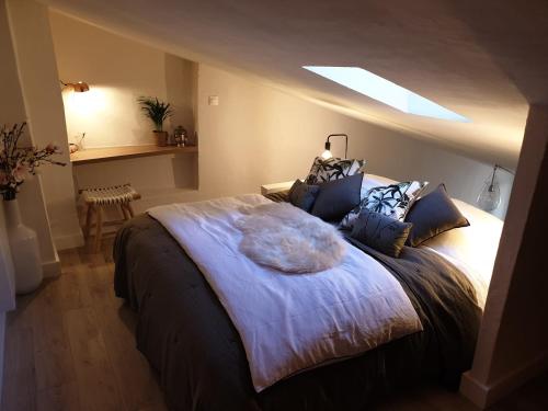 une chambre avec un grand lit avec une lucarne dans l'établissement Joli Appart Climatisé Hyper Calme Quartier Mairie, à Aix-en-Provence