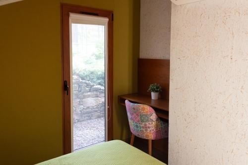 a bedroom with a desk and a chair and a window at Ecofurtado in Furtado