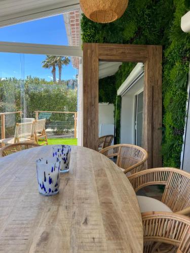 une table de salle à manger avec des chaises et une grande fenêtre dans l'établissement VILLA LA QUIETUDE, aux Issambres