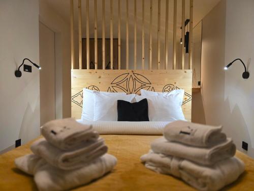 a bedroom with a bed with towels on the floor at LK Mountain Residence segmenty z prywatnym jacuzzi i widokami na góry i jezioro in Falsztyn