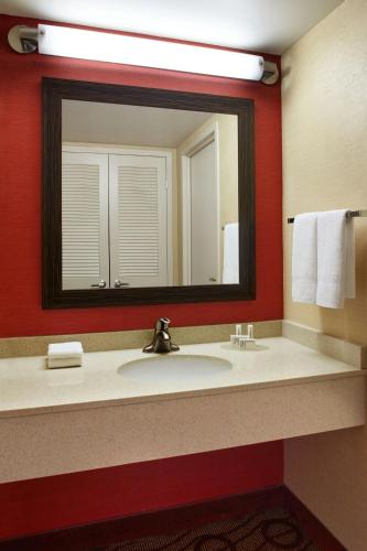a bathroom with a sink and a large mirror at Courtyard by Marriott Niagara Falls in Niagara Falls