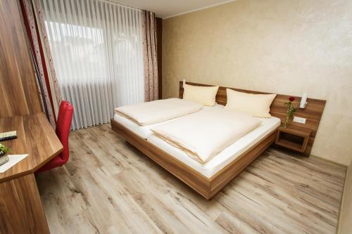 シュタイナウ・アン・デア・シュトラーセにあるバイリッシャー ホフの小さなベッドルーム(ベッド1台、赤い椅子付)