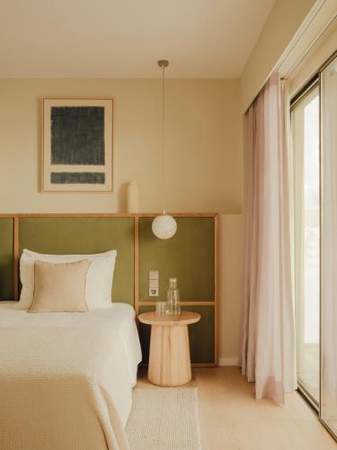 a bedroom with a bed and a table and a window at Aethos Mallorca in Paguera