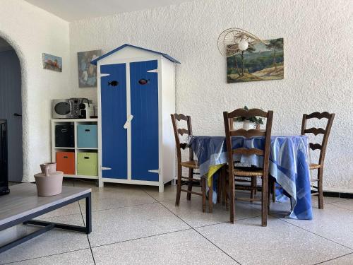 une salle à manger avec une table et une porte bleue dans l'établissement SP460-114 Maison 4 pièces - SAINT PIERRE LA MER, à Saint Pierre La Mer