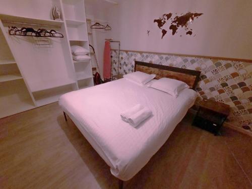 un lit avec des draps blancs et des oreillers dans une chambre dans l'établissement L'Azur - Apt 4 Prs avec jardin en centre ville, à Dijon