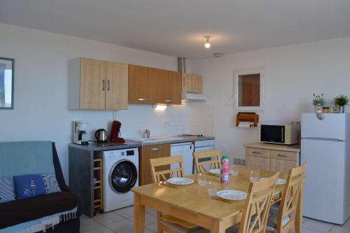 Il comprend une cuisine équipée d'une table à manger et d'un réfrigérateur. dans l'établissement SP480-153 Maison 3 pièces SAINT PIERRE LA MER, à Saint Pierre La Mer