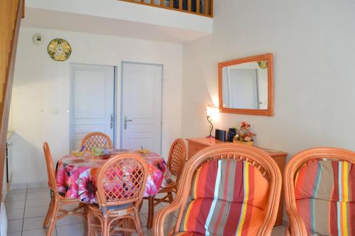 une salle à manger avec une table, des chaises et un miroir dans l'établissement SP480-165 Maison 2 pièces mezzanine SAINT PIERRE LA MER, à Saint Pierre La Mer