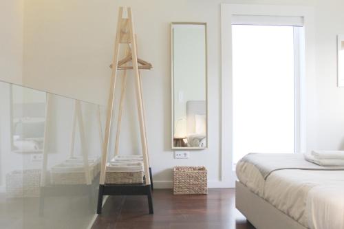 Cette chambre comprend un lit, un miroir et une échelle. dans l'établissement Typical Quarter Nest, à Porto