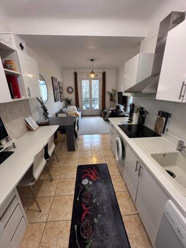 - une cuisine avec des placards blancs et un tapis de cuisine à l'étage dans l'établissement Appartement avec balcon, 5 min du Métro 1-6, Nation, Disneyland, Zoo, Bois de Vincennes, à Paris