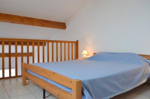 - une chambre avec un lit bleu et une balustrade en bois dans l'établissement SP480-166 Maison 2 pièces mezzanine SAINT PIERRE LA MER, à Saint Pierre La Mer