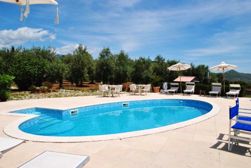 a pool with chairs and tables and umbrellas at Villa Saha splendida dimora immersa tra gli ulivi in Itri