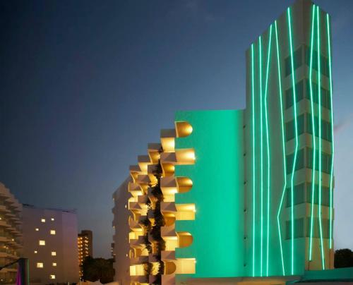 a green building with yellow lights on the side of it at BG Pamplona in Playa de Palma