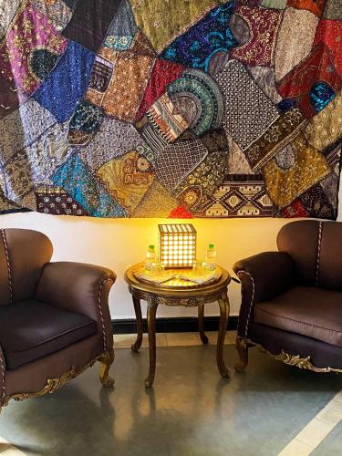 a room with two chairs and a table in front of a quilt at Riad Palais Bahia Fes in Fès