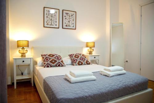 a bedroom with a white bed with towels on it at Superb New Family Apartment VIPGreece in Athens