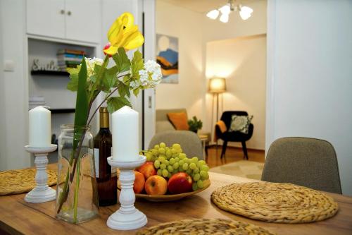 a table with a vase of flowers and a bowl of fruit at Superb New Family Apartment VIPGreece in Athens