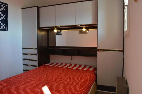 une chambre avec un lit rouge dans une pièce dans l'établissement SP520-B129 Appartement 2 pièces SAINT PIERRE LA MER, à Saint Pierre La Mer