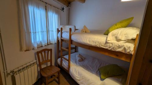 a small room with two bunk beds and a chair at Camping Solau in Espot
