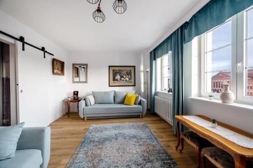 a living room with a couch and a table at Motlawa River Apartment in Gdańsk
