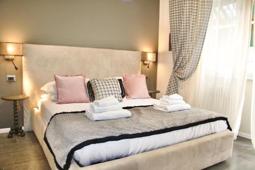 a bedroom with a bed with pink and white pillows at Xcross Suites Garbatella in Garbatella