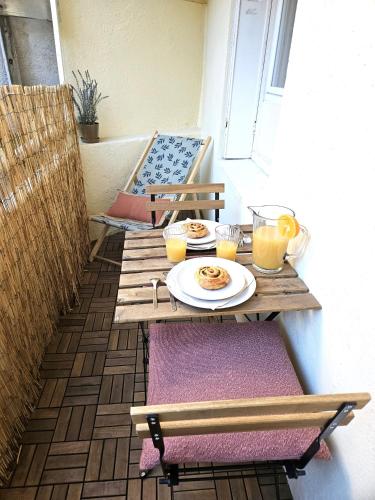 - une table avec une assiette de nourriture sur la terrasse dans l'établissement Hypercentre-le petit Marseillais - Clim&Balcon, à Marseille