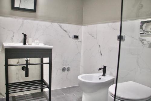 a bathroom with a toilet and a sink and a shower at Xcross Suites Garbatella in Garbatella