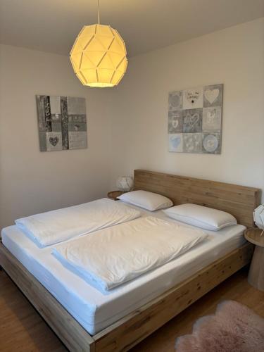 a bedroom with a bed with white sheets and a lamp at Ferienwohnung Simon in Freudenstadt
