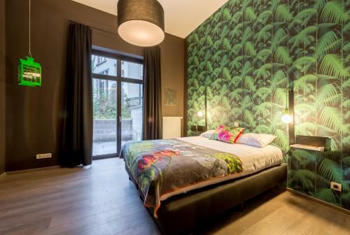 sypialnia z łóżkiem i zieloną ścianą w obiekcie Smartflats Design - Schuman w Brukseli