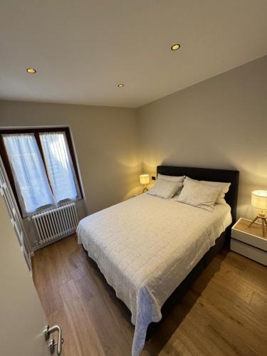 a bedroom with a large bed and two windows at Breva's Flat near Bellagio in Bellagio