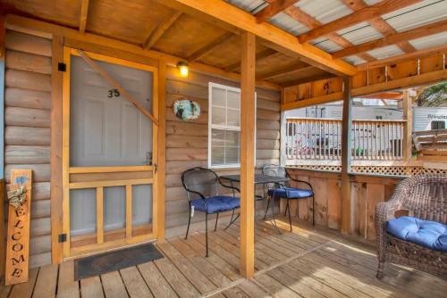 a cabin with a porch with a table and chairs at 1BR Cabin in the Smokies Close to Gatlinburg in Gatlinburg