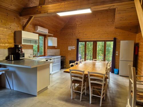 une cuisine avec une grande table et des chaises en bois dans l'établissement Les Cottages de Charme, à Saint-Aignan