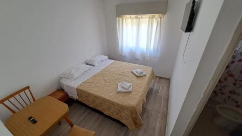 una piccola camera da letto con un letto e una sedia di Bagu Express a Villa Gesell