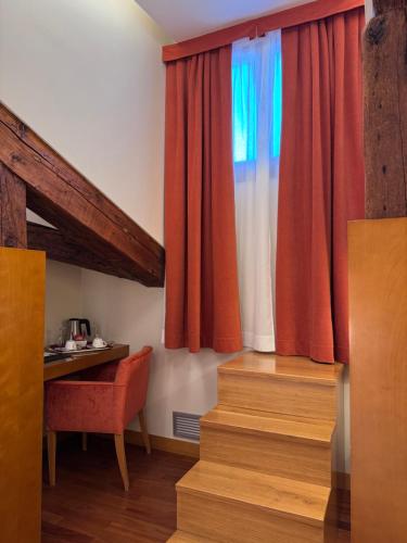 a room with a desk and a window and stairs at Ruzzini Palace Hotel in Venice