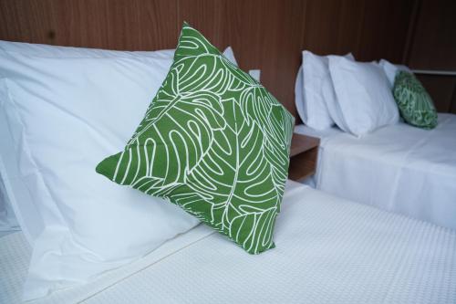 a green and white pillow sitting on top of a bed at Arraial Concept Hotel in Arraial do Cabo