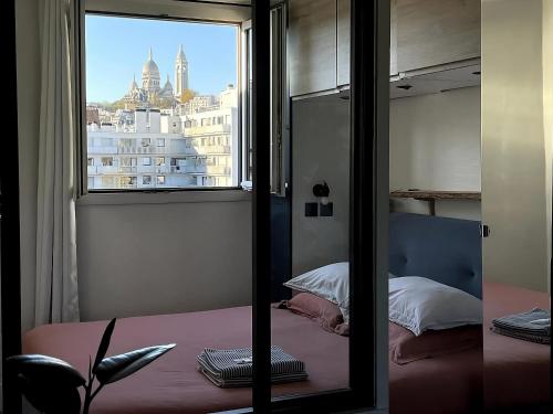 une chambre avec vue sur une ville depuis une fenêtre dans l'établissement Superbe Loft avec Vue Incroyable sur Montmartre, à Paris