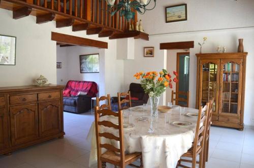 une salle à manger avec une table avec un vase de fleurs dans l'établissement Maison 4 pièces 7 couchages ARGELES SUR MER AR000-067, à Argelès-sur-Mer
