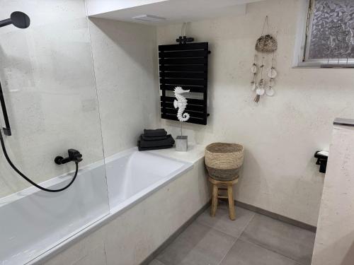 a bathroom with a bath tub and a stool at Gemütliches Kellerzimmer + Bad in Bocholt