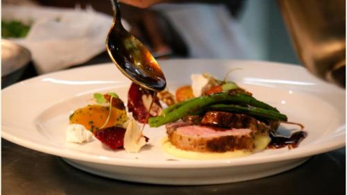 a plate of food on a table with a spoon at Schloss Krugsdorf Golf & Hotel in Krugsdorf